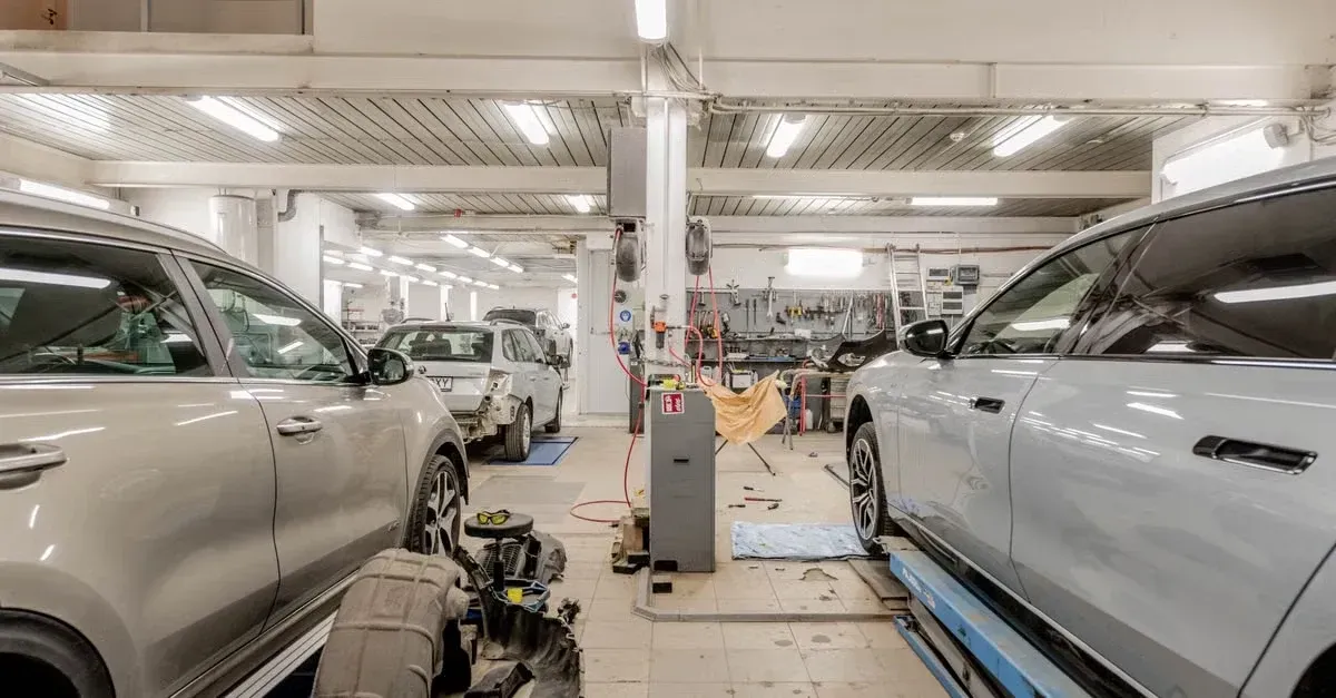 Professional auto repair shop with multiple vehicles on lifts and mechanics working, demonstrating digital marketing.