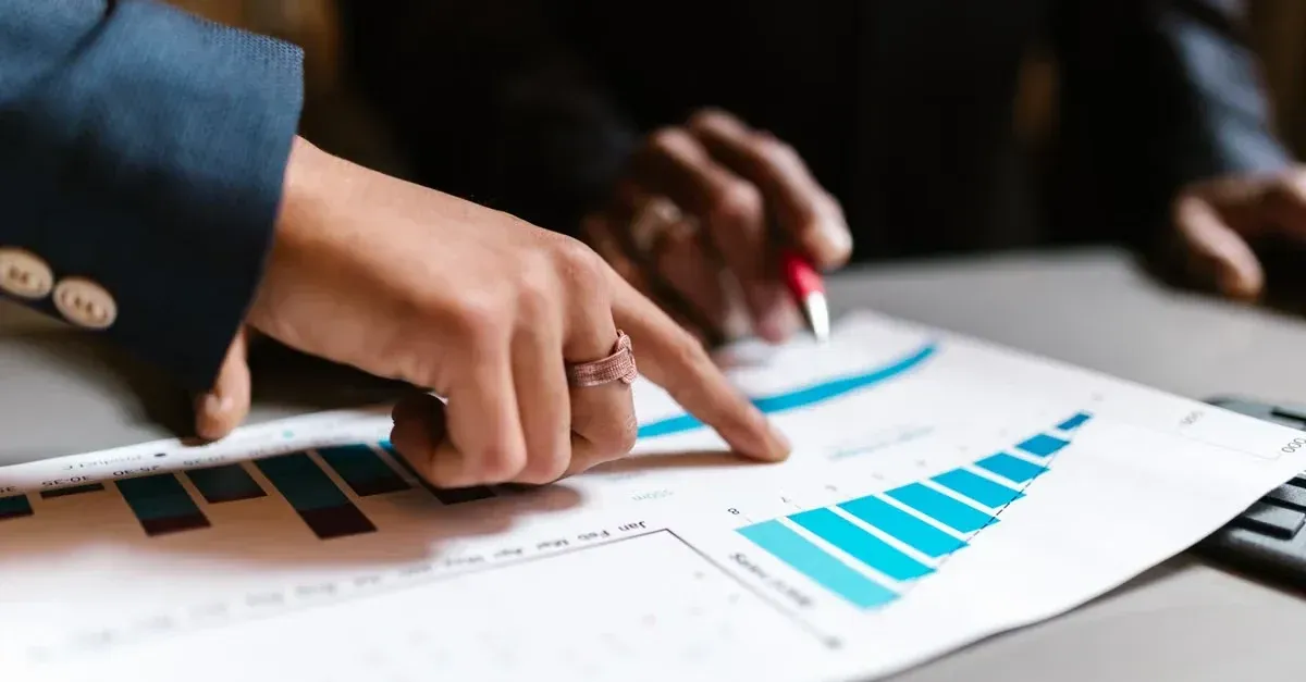 Business professional pointing at blue bar chart showing SEO ROI calculator metrics.