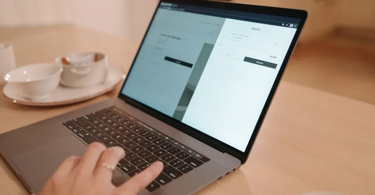 Person typing on laptop displaying split-screen web pages while working on automotive website SEO strategy at desk.