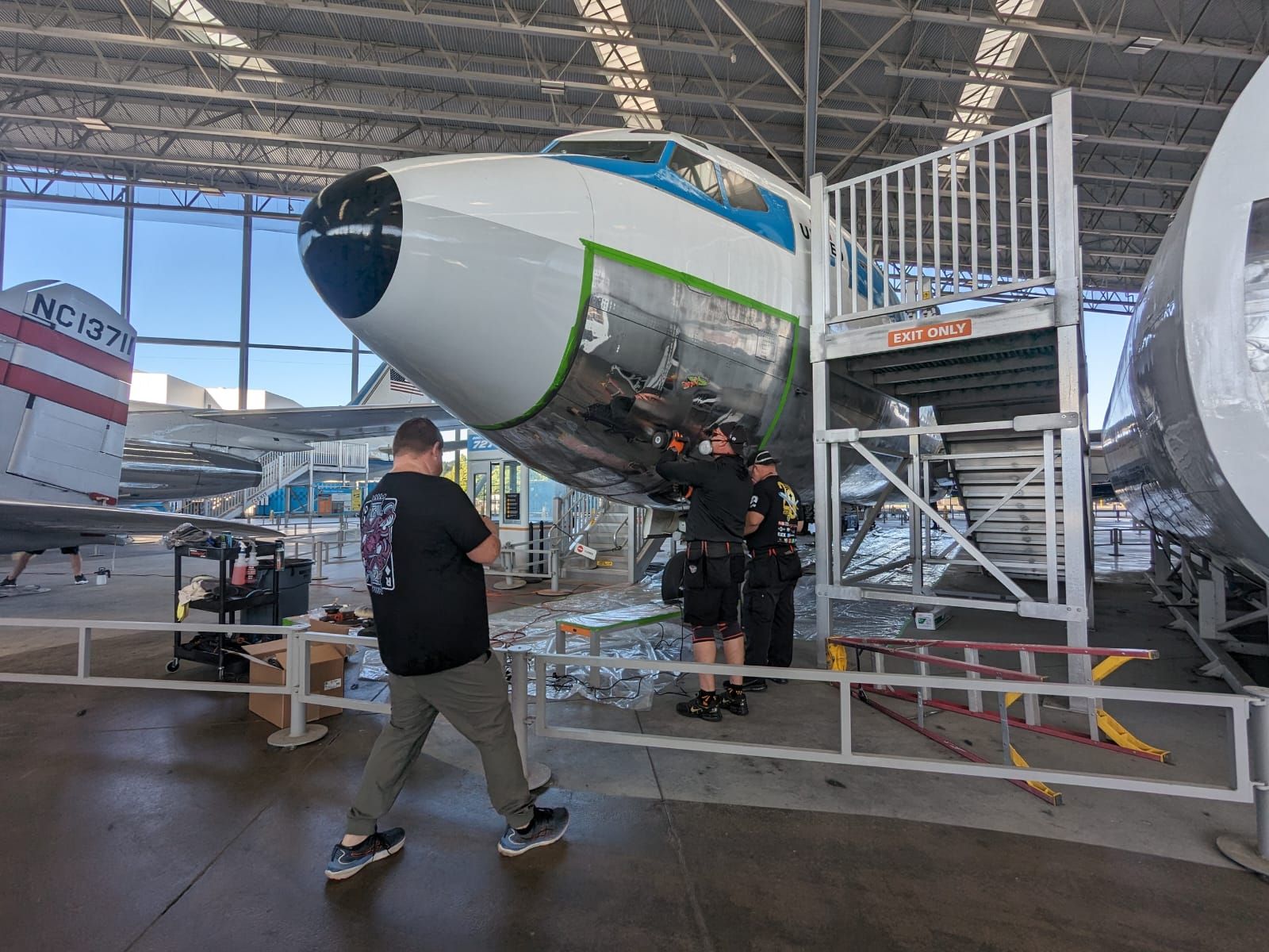A group of men are working on an airplane in a hangar.