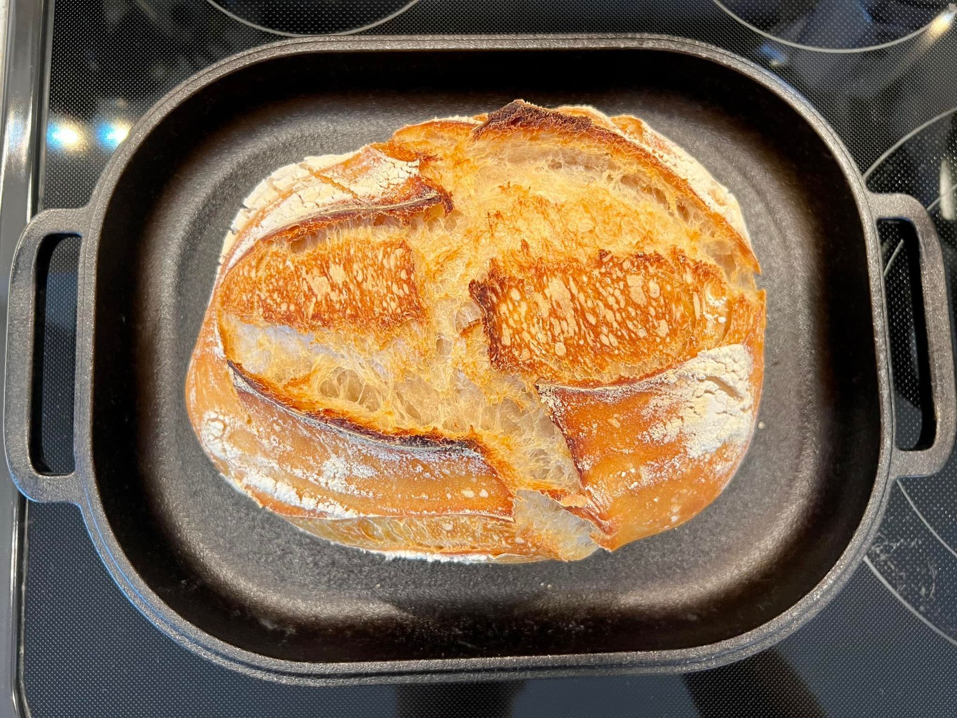 A loaf of bread is sitting in a pan on a stove.