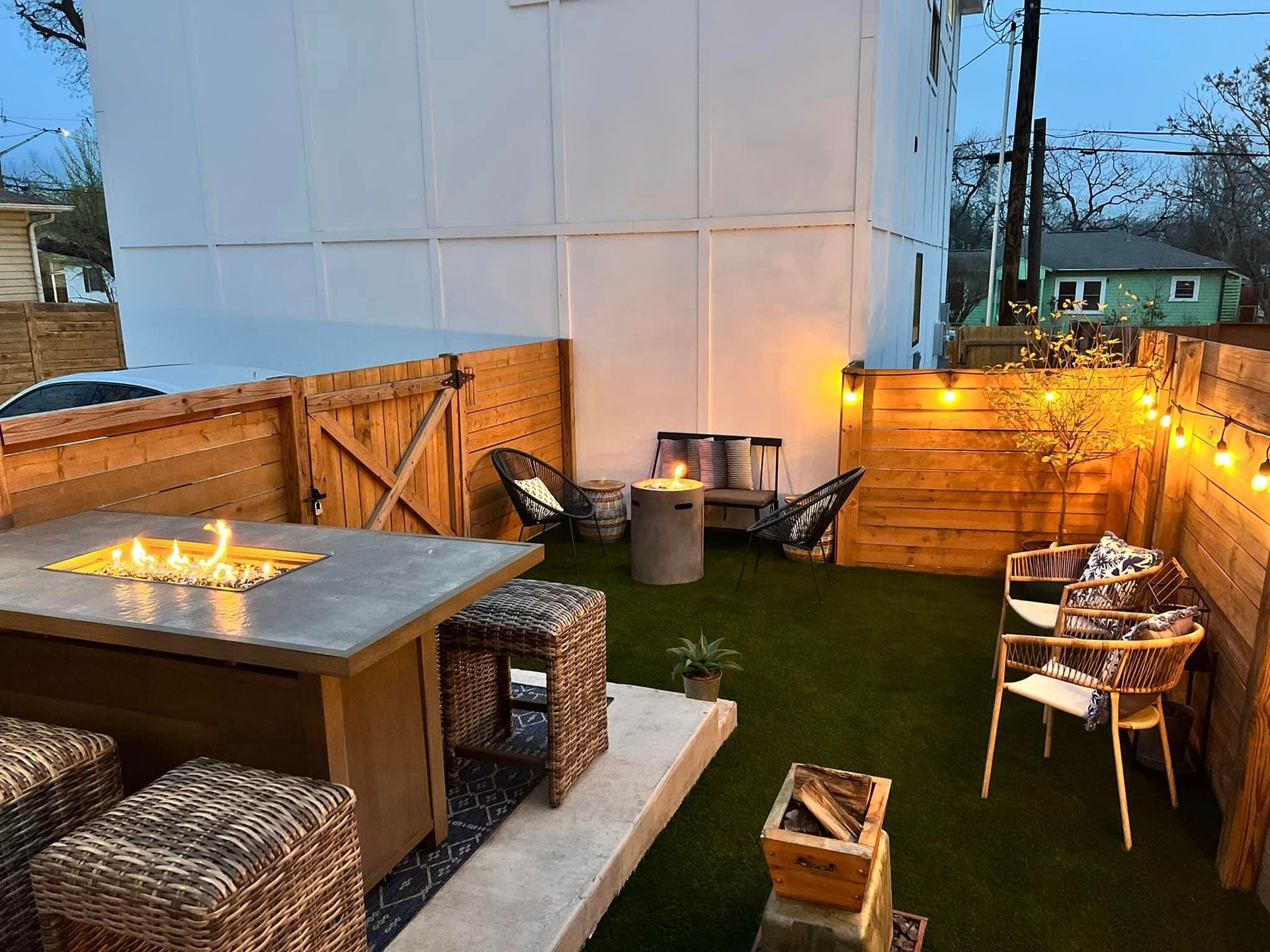 A patio with a table and chairs and a fire pit.