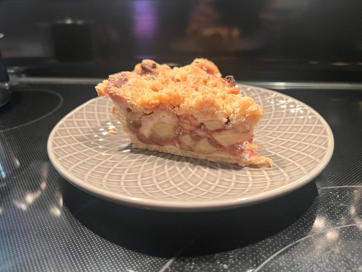 A slice of pie is on a plate on a stove.