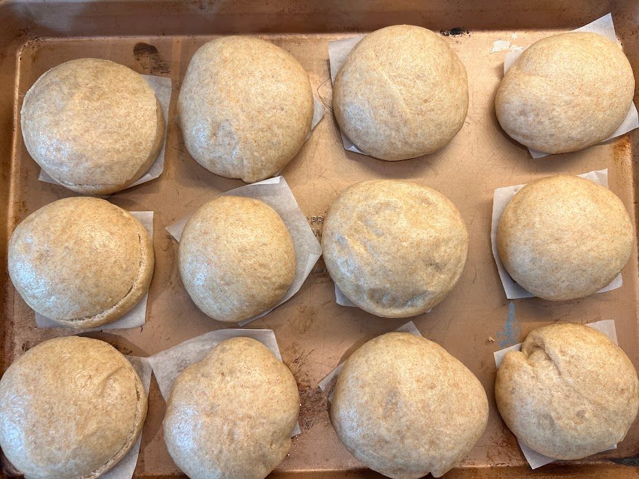 A bunch of dough balls are sitting on top of a baking sheet.