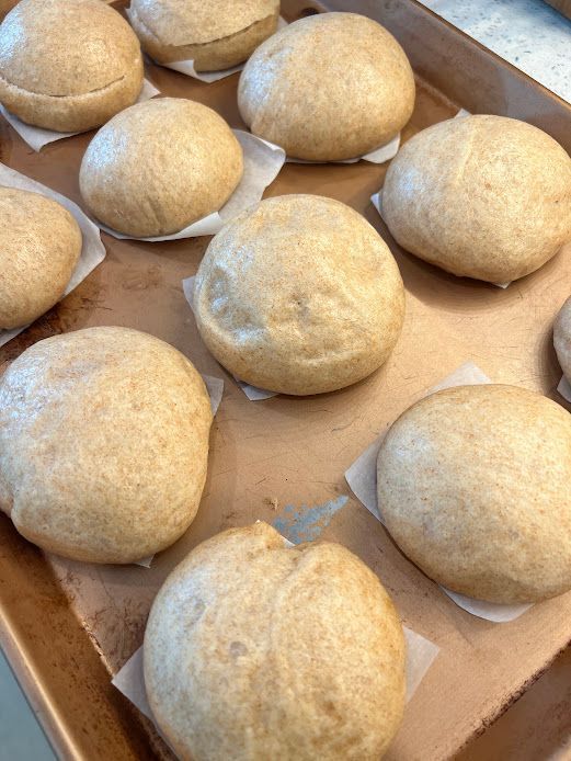 A bunch of dough balls are sitting on top of a baking sheet.
