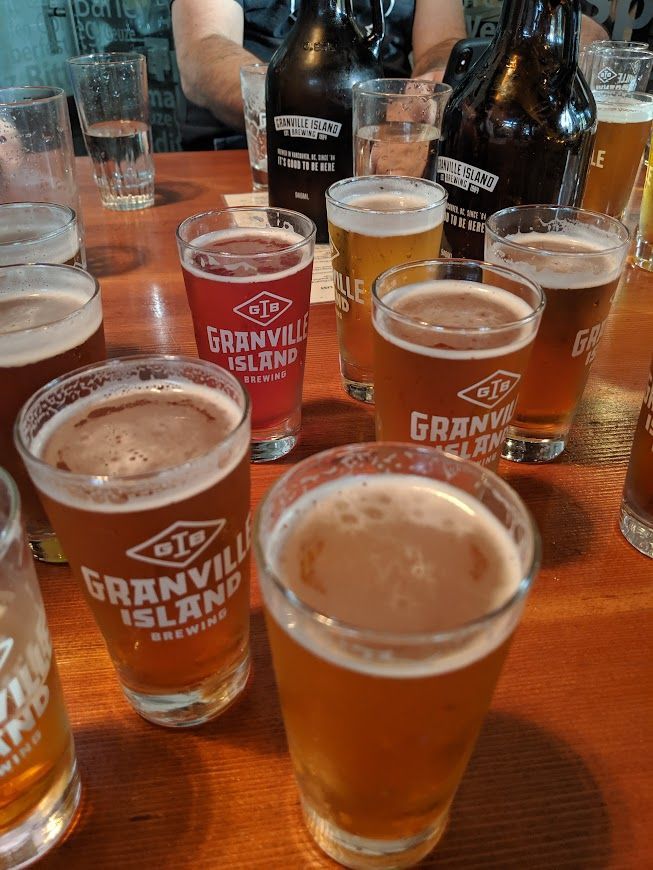 A table topped with glasses of beer and bottles of beer.