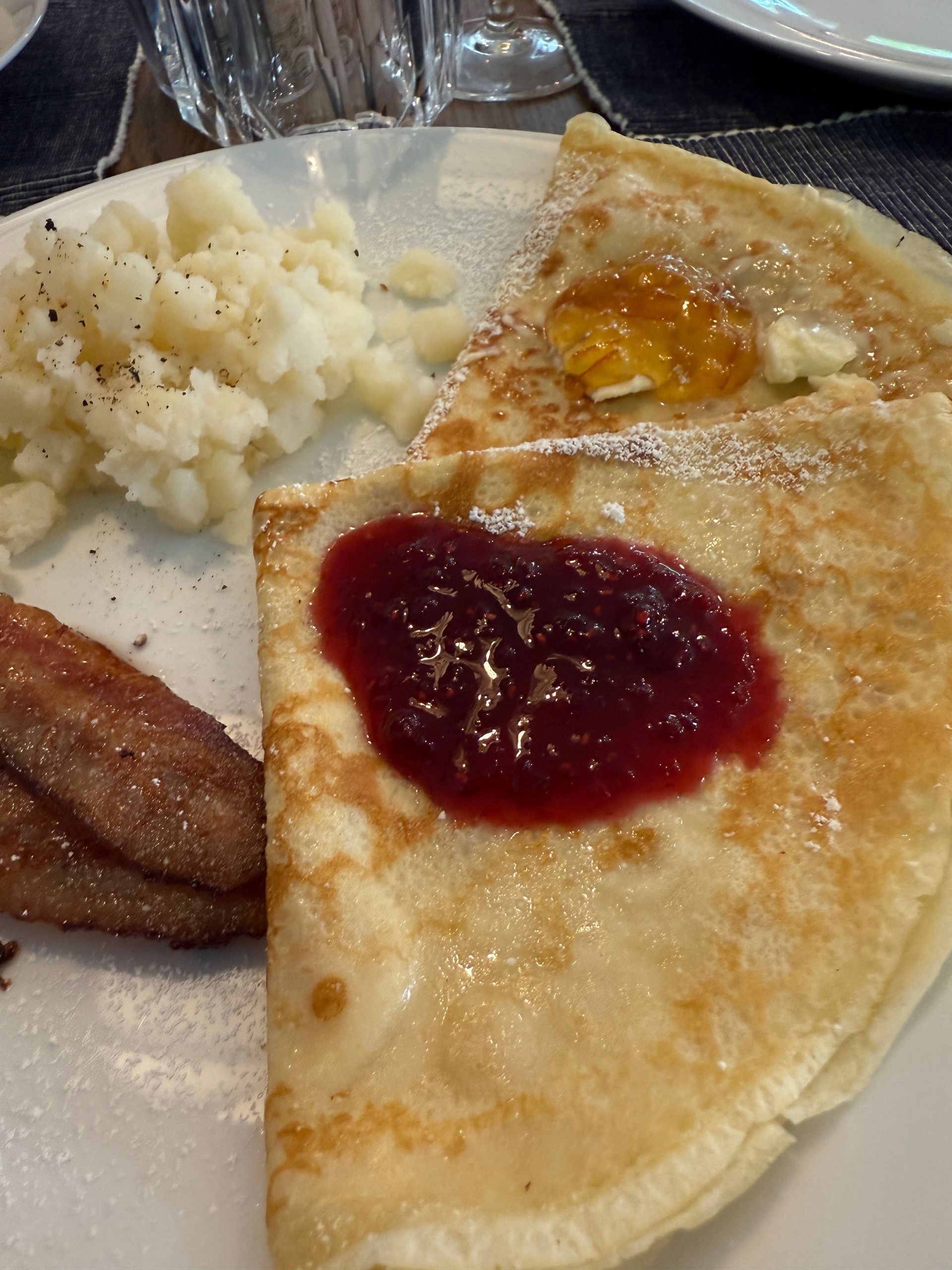 A close up of a plate of food with a crepe and diced potatoes