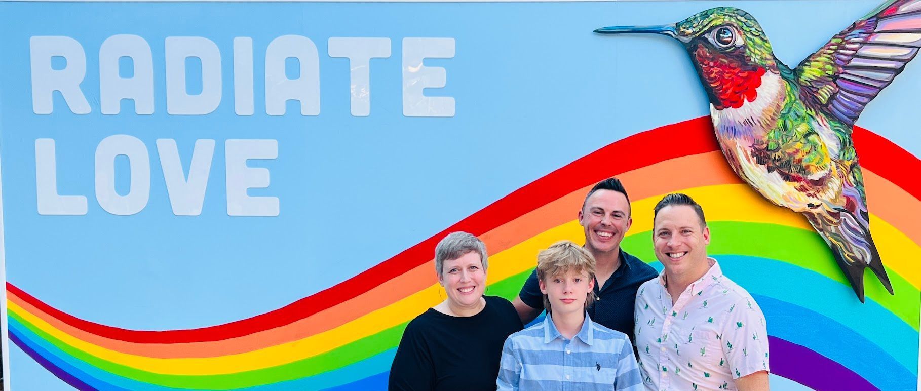 A group of people standing in front of a sign that says radiate love