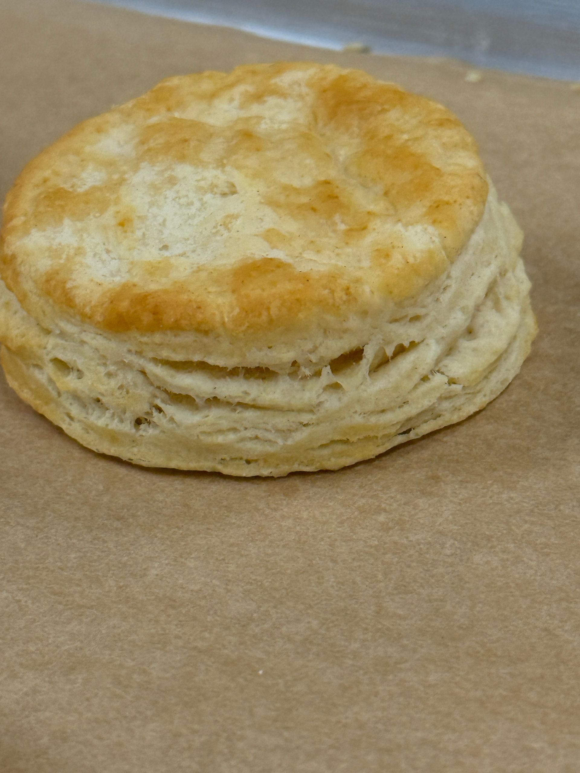 A biscuit is sitting on a piece of brown paper.
