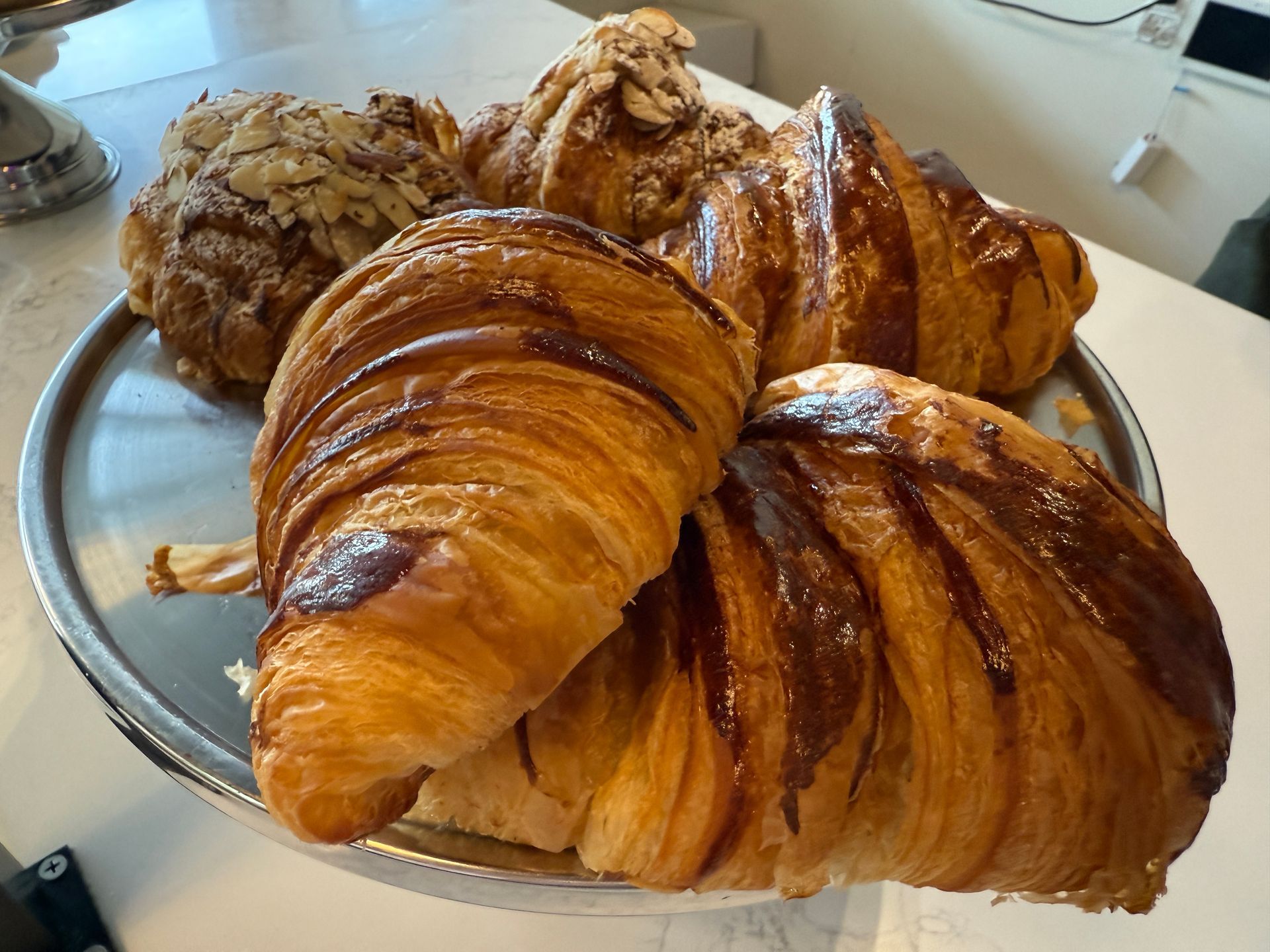 A tray of croissants and pastries on a table.