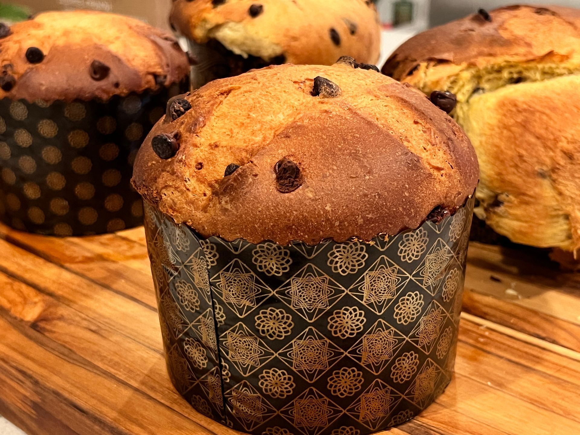 A panettone is sitting on a wooden cutting board.