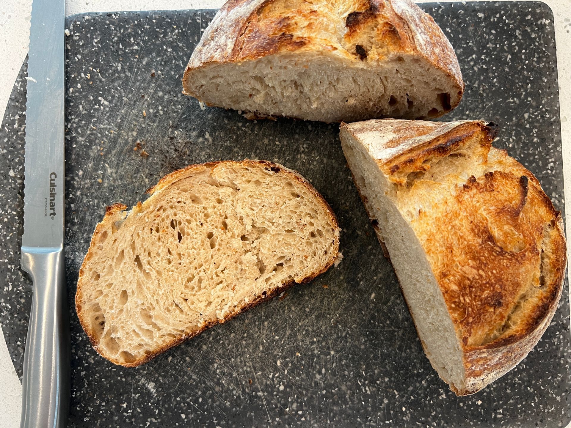 A slice of loaf cut from the bread is sitting on a cutting board.