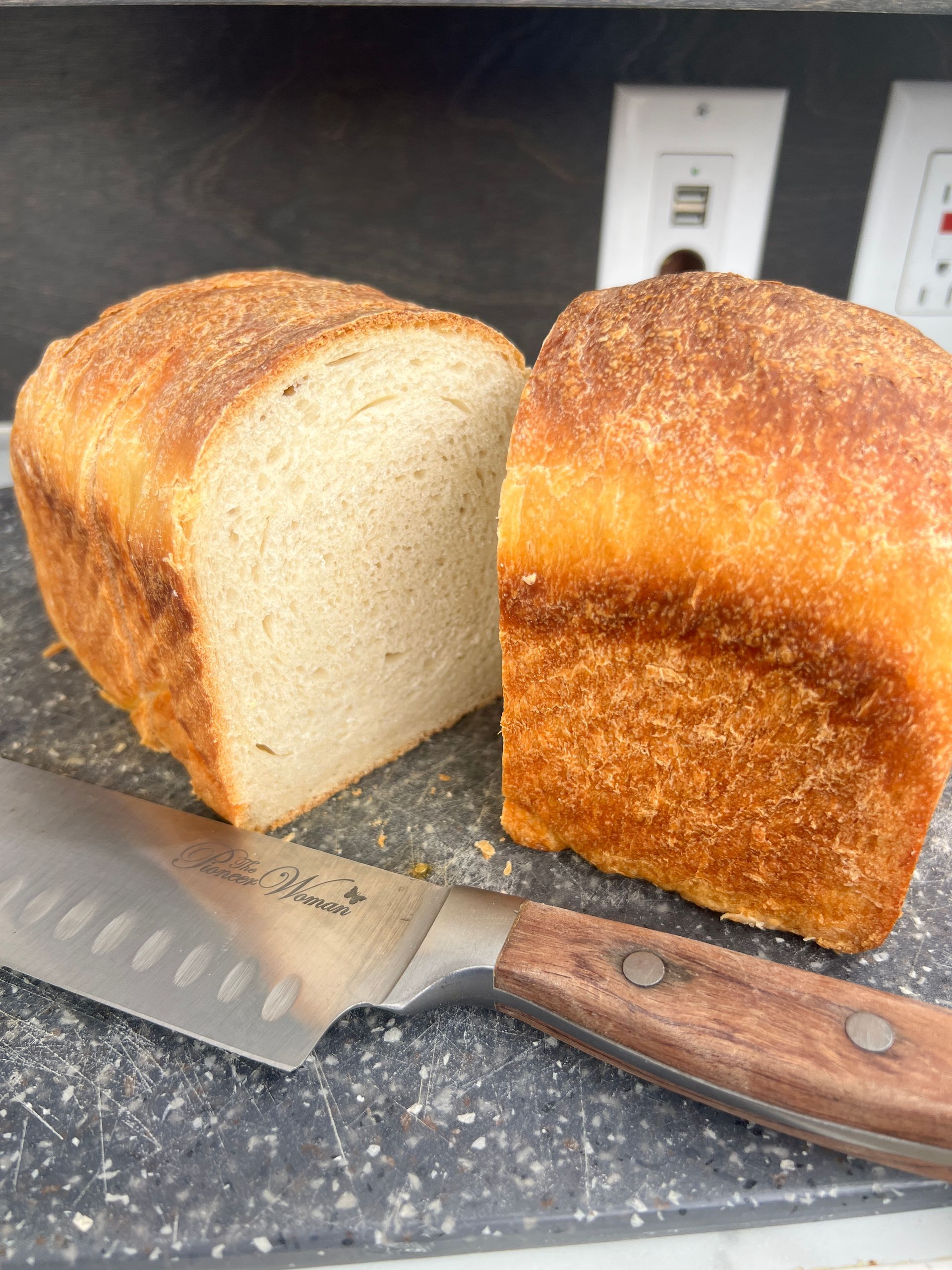 a loaf of bread cut in half is sitting on a cutting board