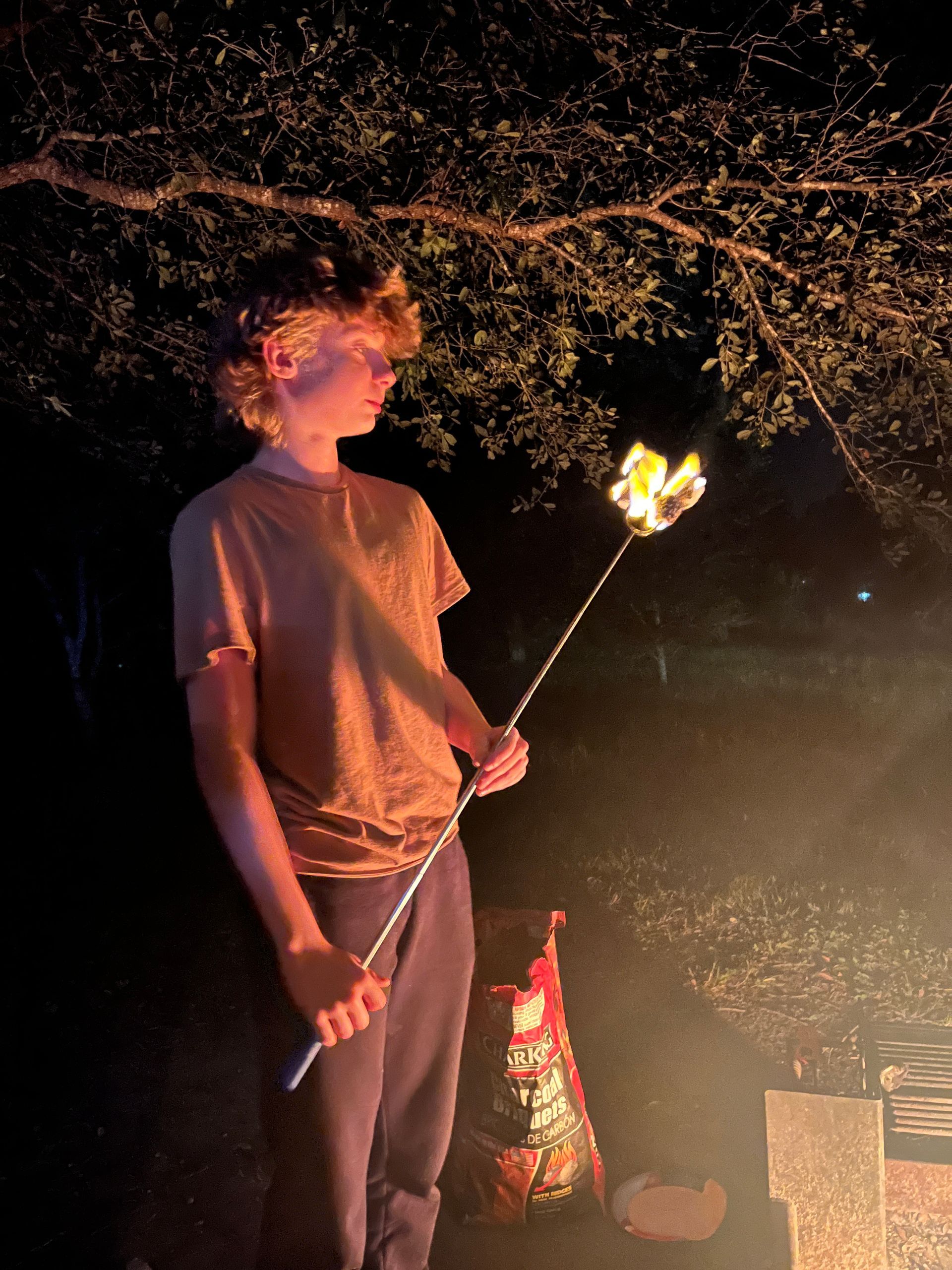 a young camper roasts marshmallows over fire