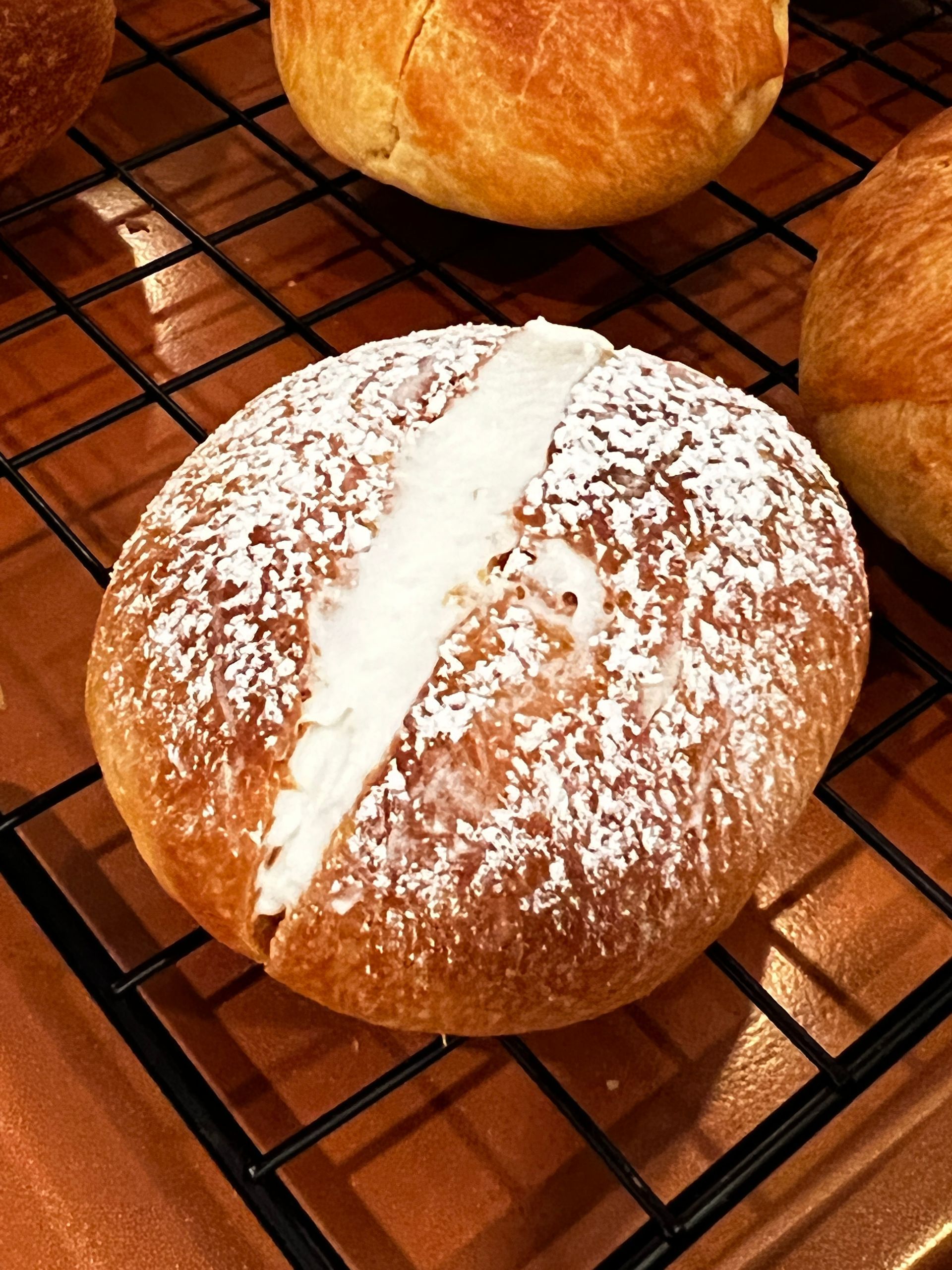 An italian sweet bread with powdered sugar on it is sitting on a cooling rack.