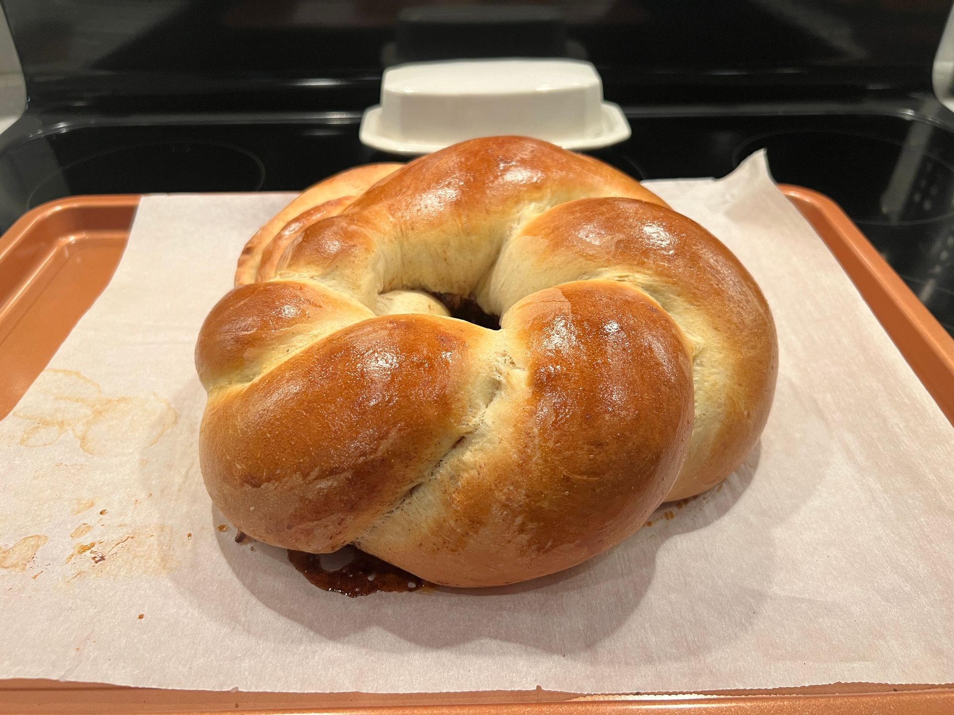 A loaf of bread is sitting on a piece of wax paper on a tray.
