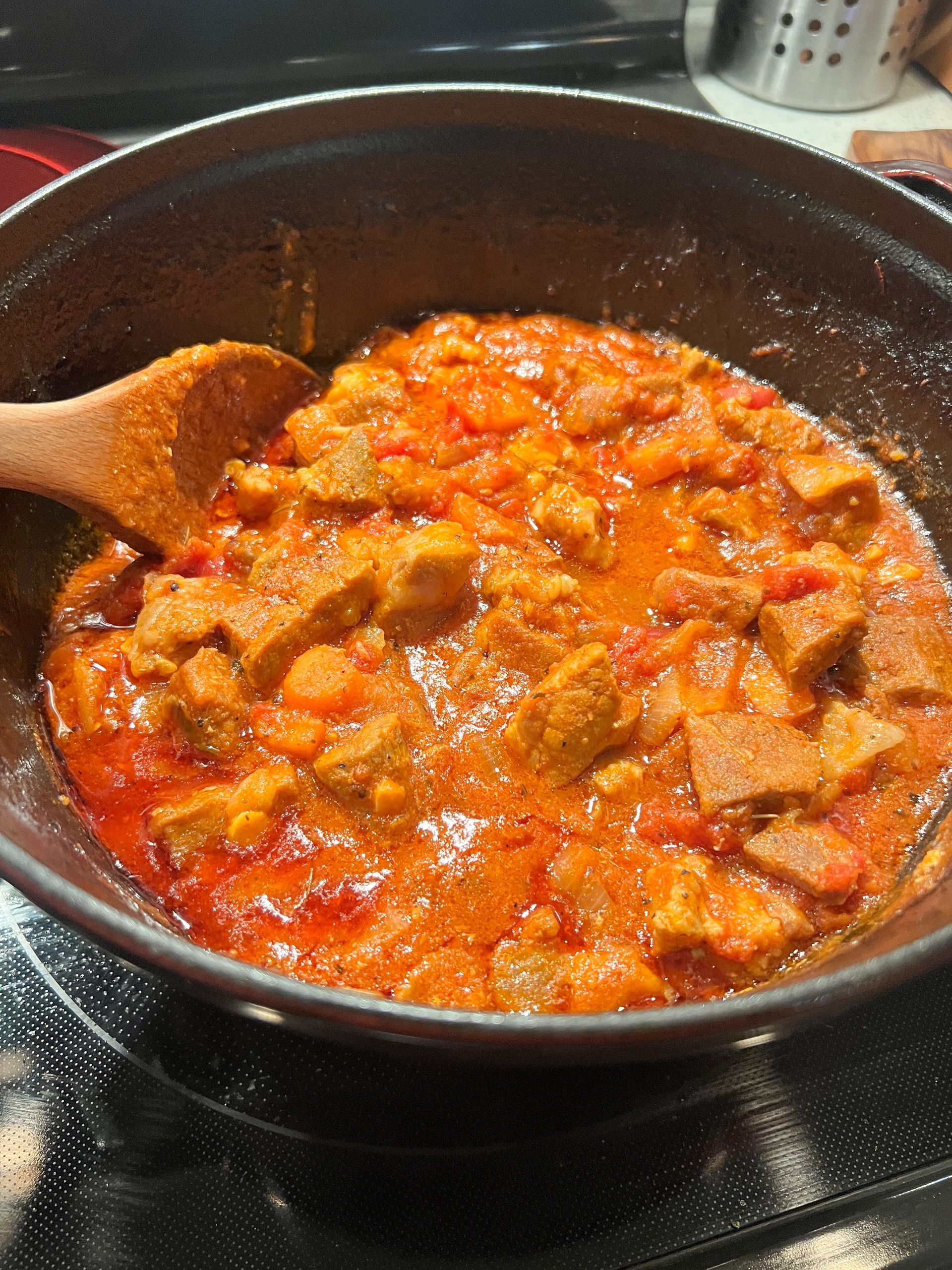 A pot of stew with a wooden spoon in it