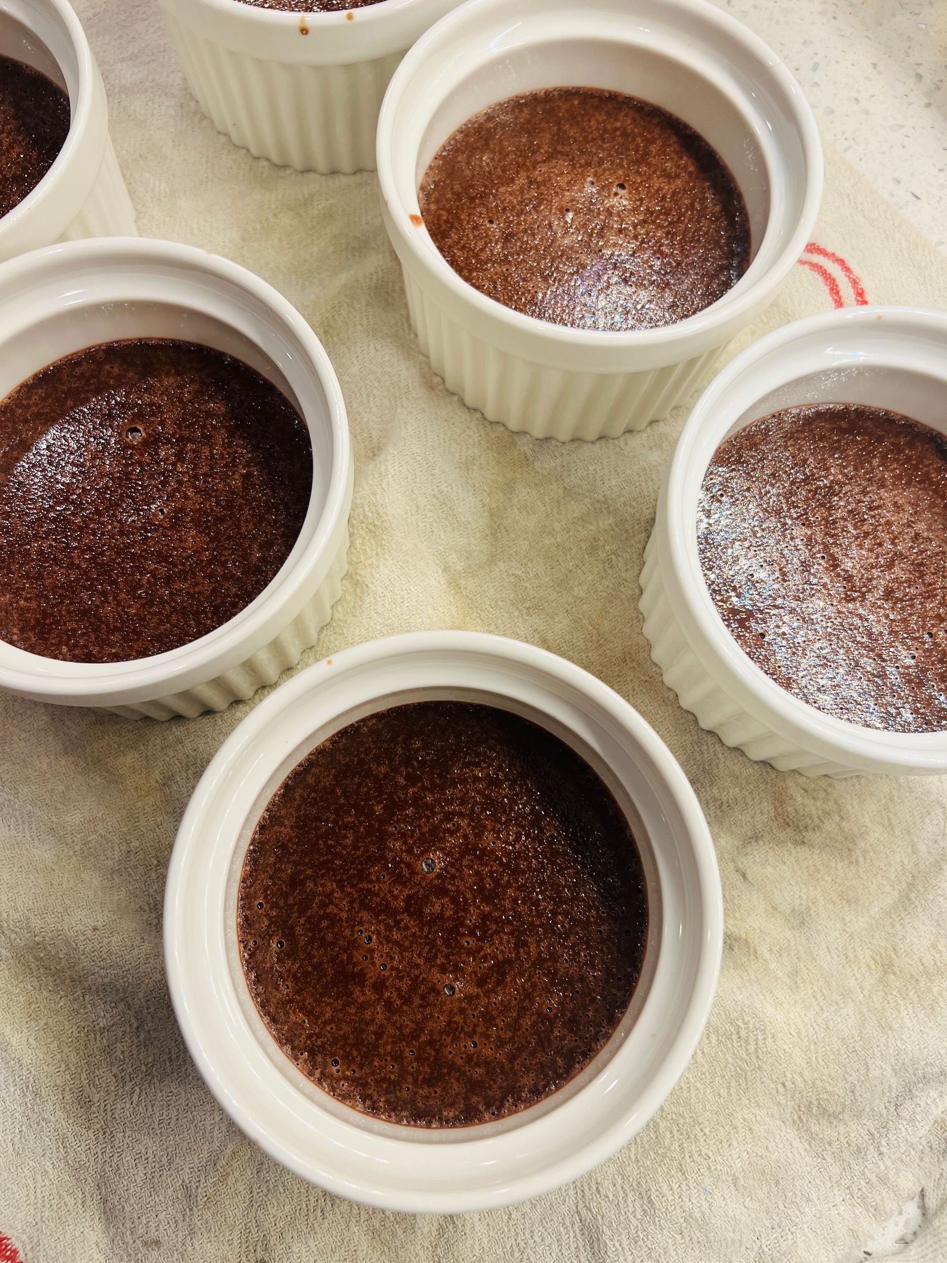 Four bowls of chocolate creme brulee are sitting on a table