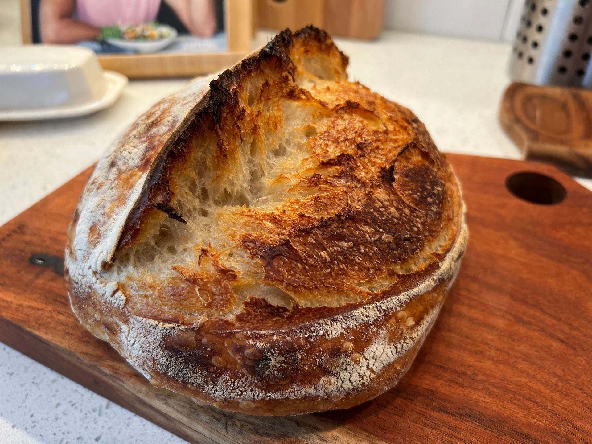 A loaf of bread is sitting on a wooden cutting board.