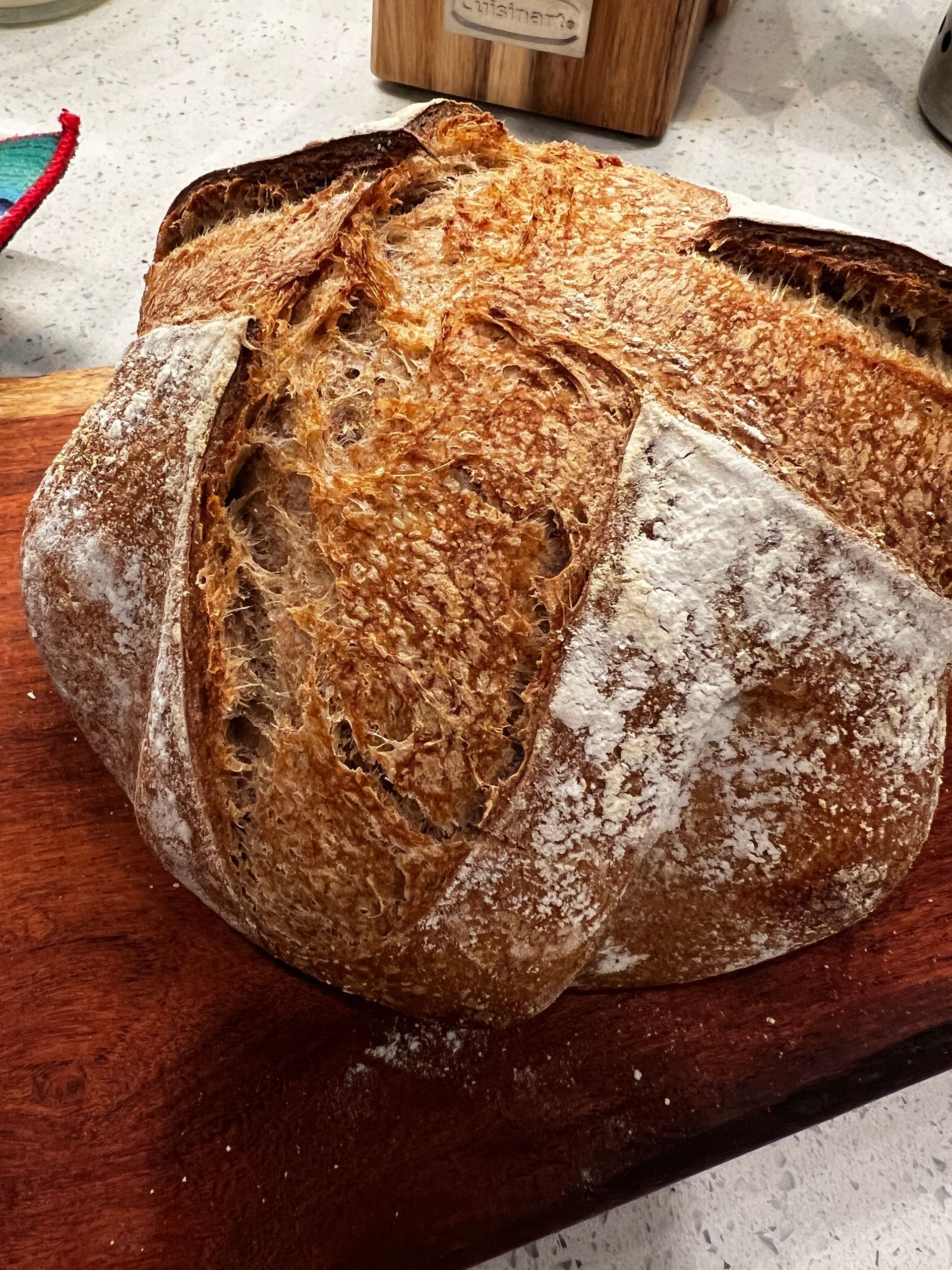 A loaf of bread is sitting on a wooden cutting board.