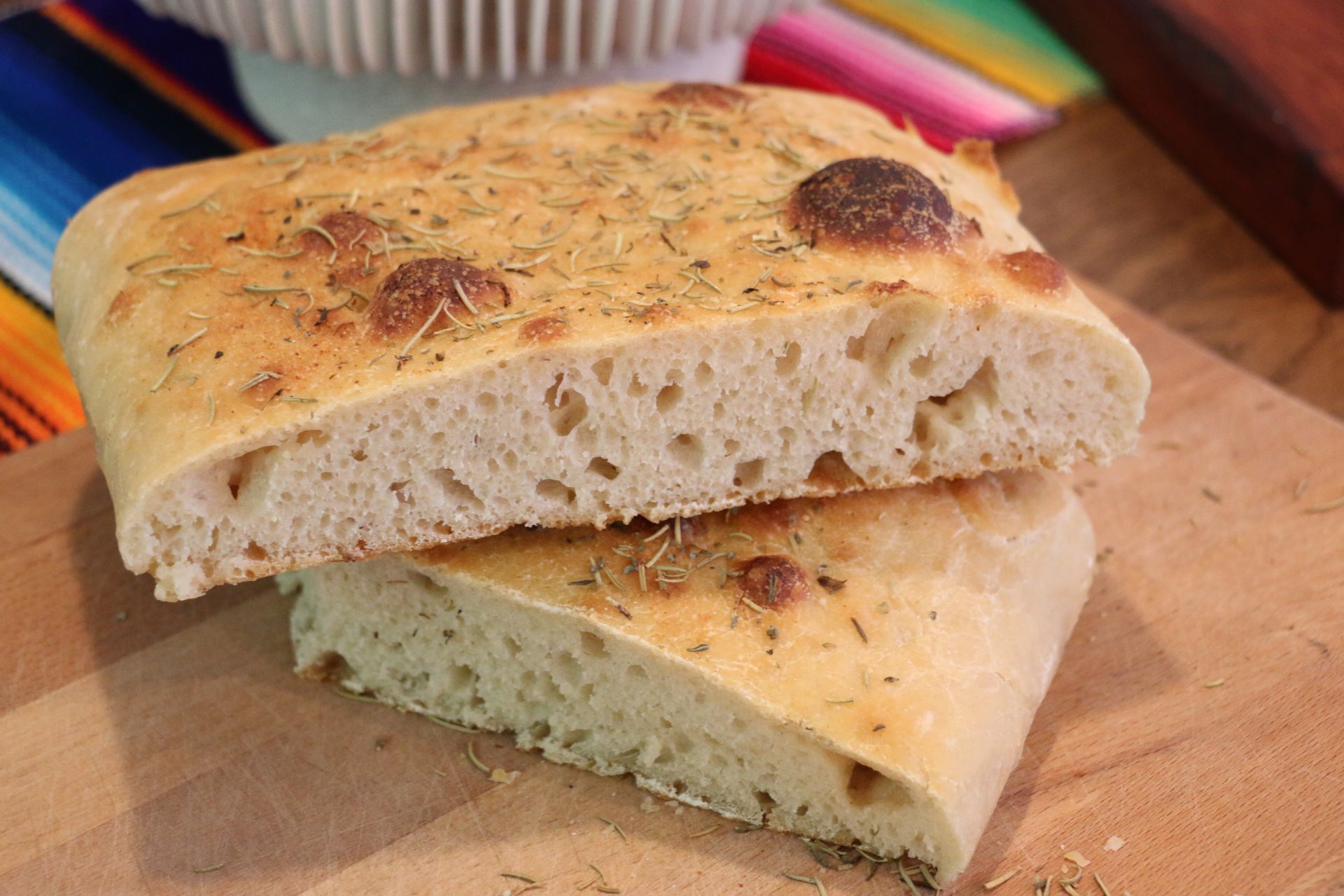 Two slices of bread are stacked on top of each other on a wooden cutting board.