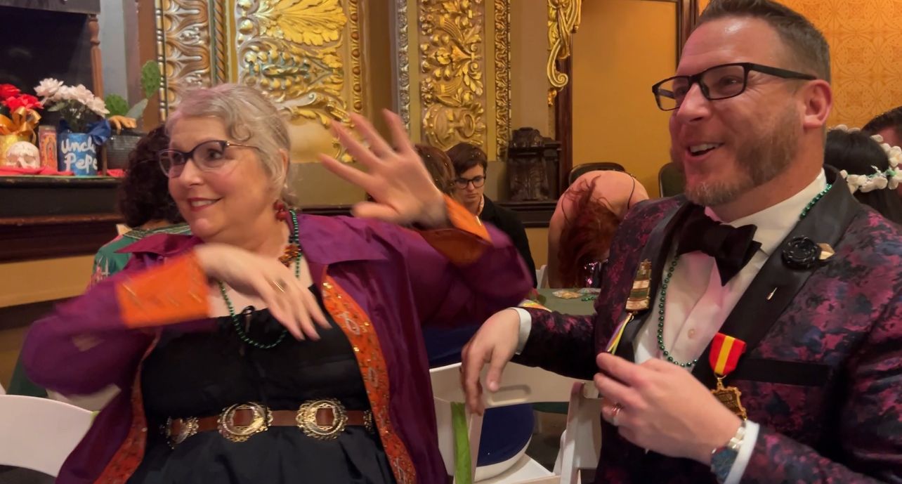 A man and a woman are dancing together in a room.