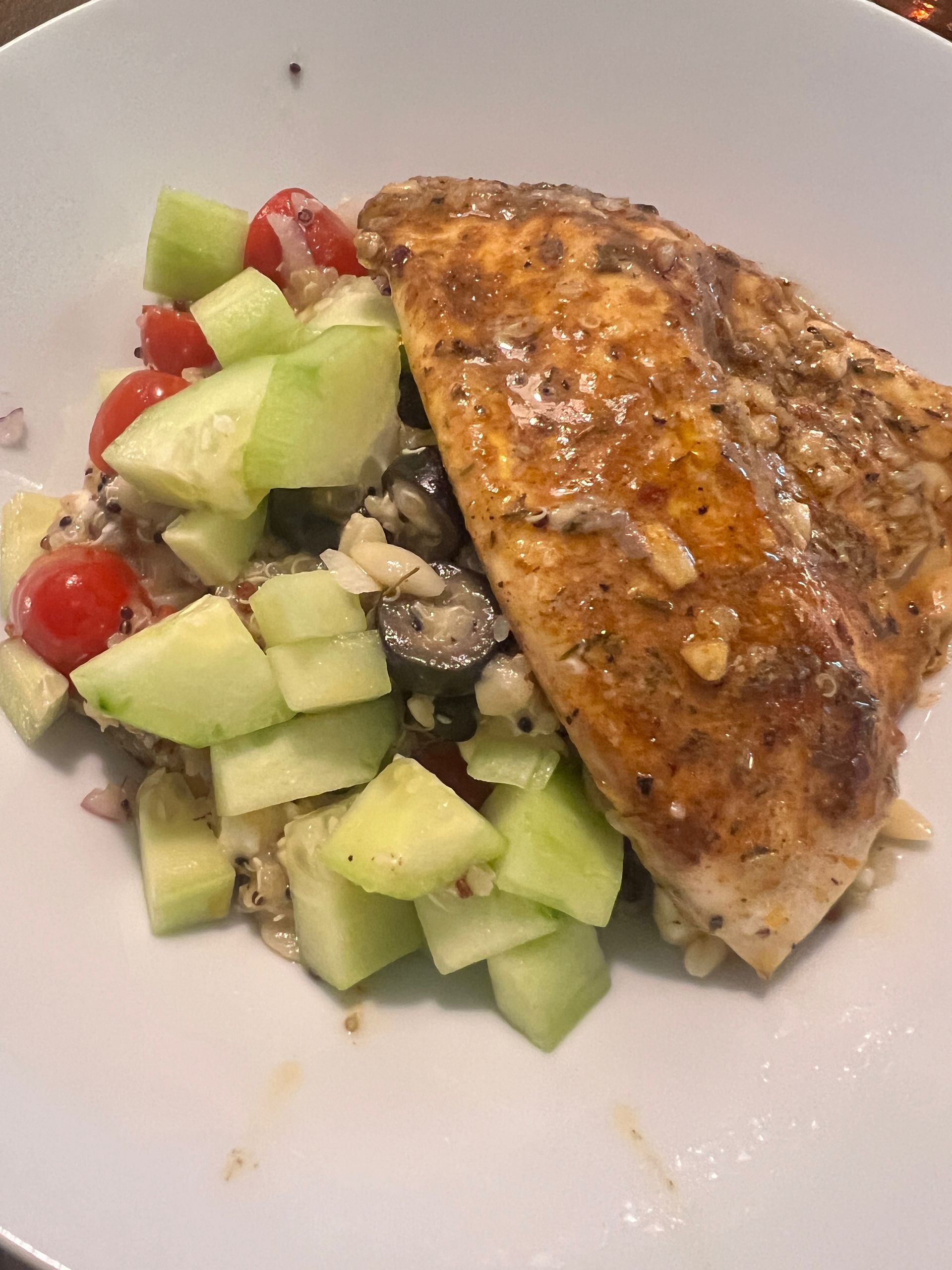 A white plate topped with a piece of meat and a salad.