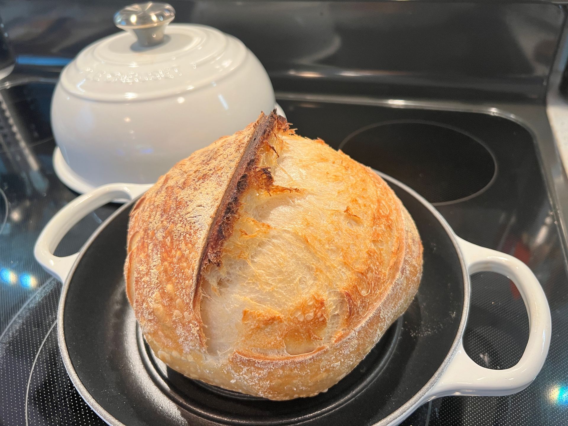 A loaf of bread is sitting on a plate on a stove.