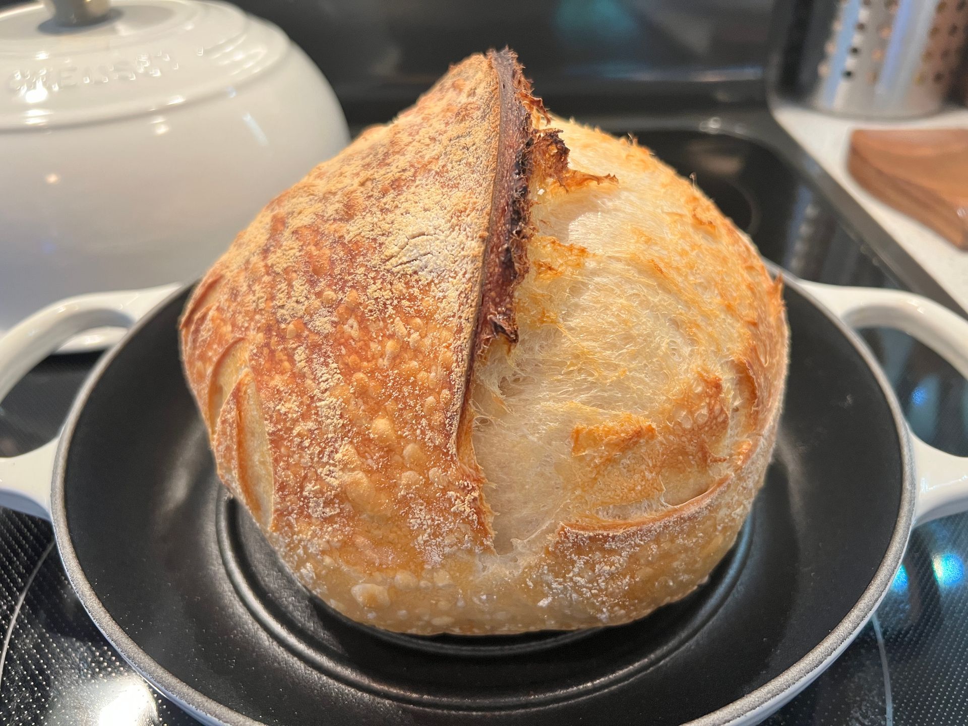 A loaf of bread is sitting on top of a pan on a stove.