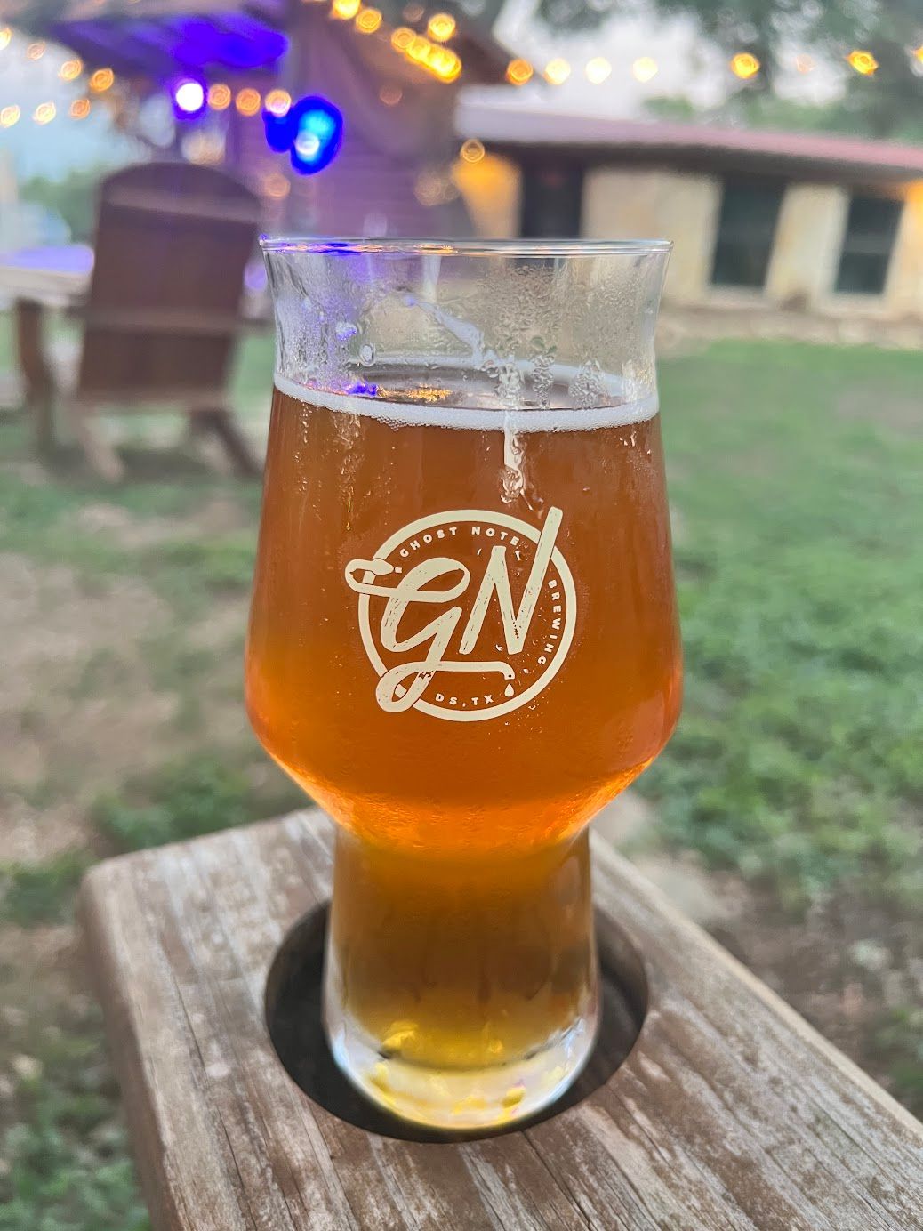 A glass of beer is sitting on a wooden table.