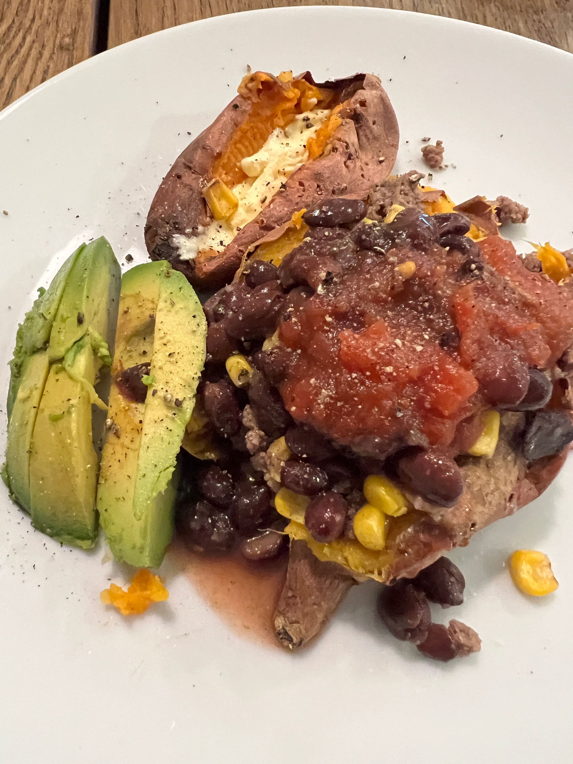 A plate of food with beans and avocado on it