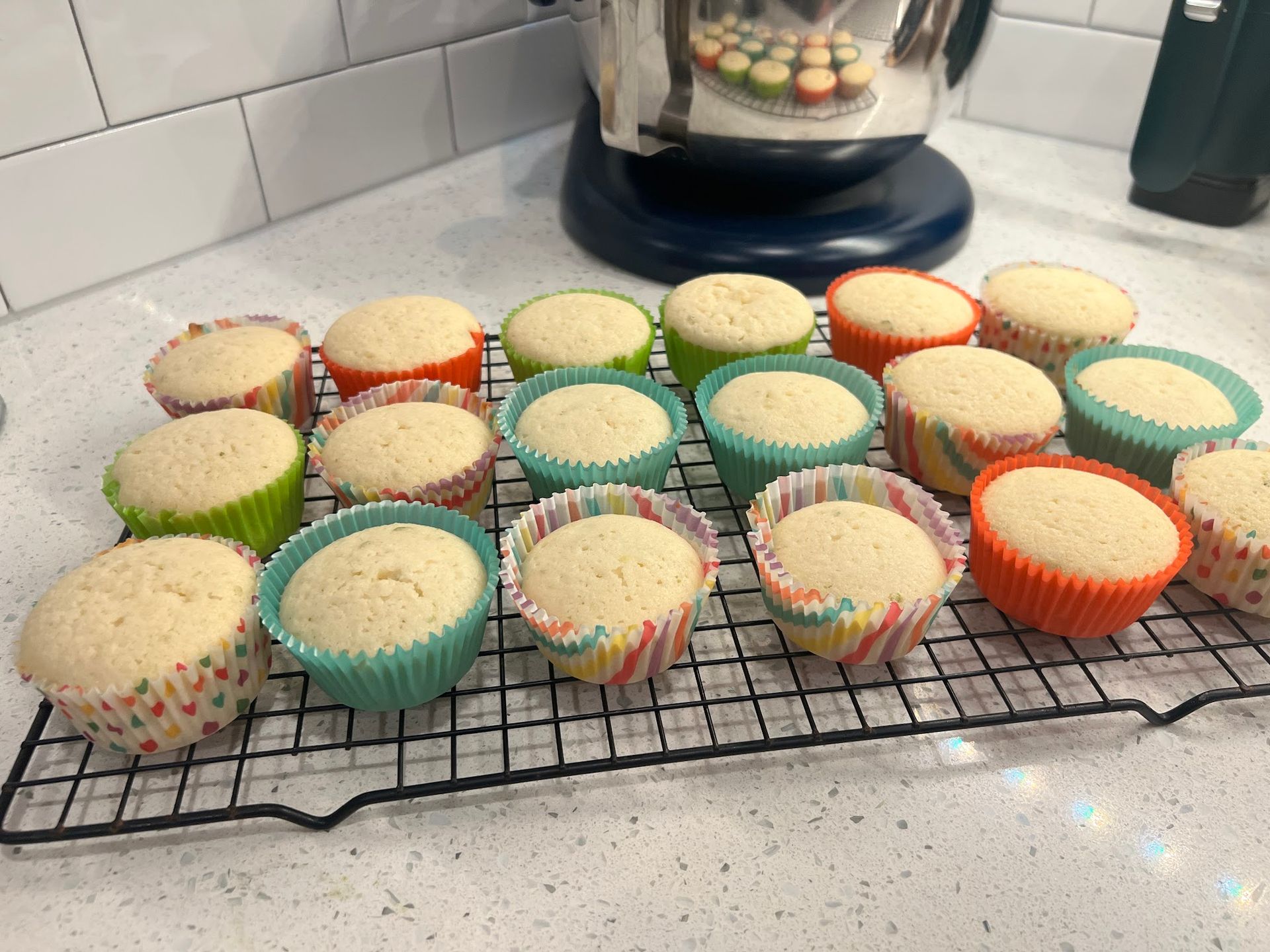 A bunch of cupcakes are sitting on a cooling rack
