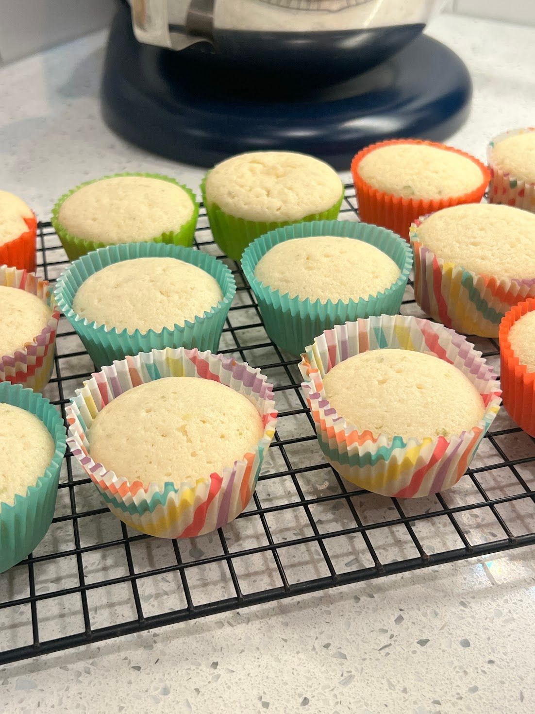 A bunch of cupcakes are sitting on a cooling rack