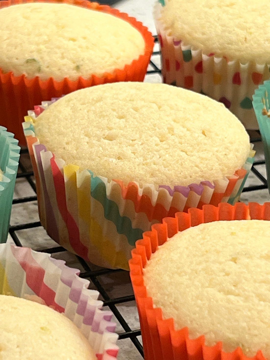 A bunch of cupcakes are sitting on a cooling rack