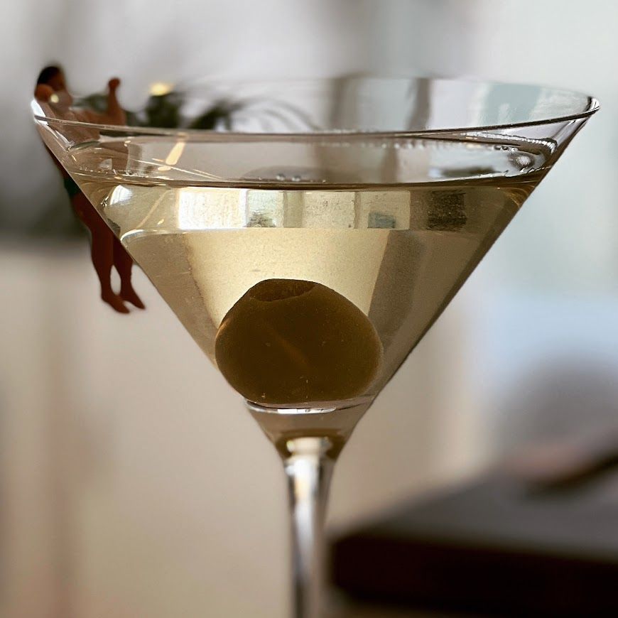 A martini glass with an olive in it