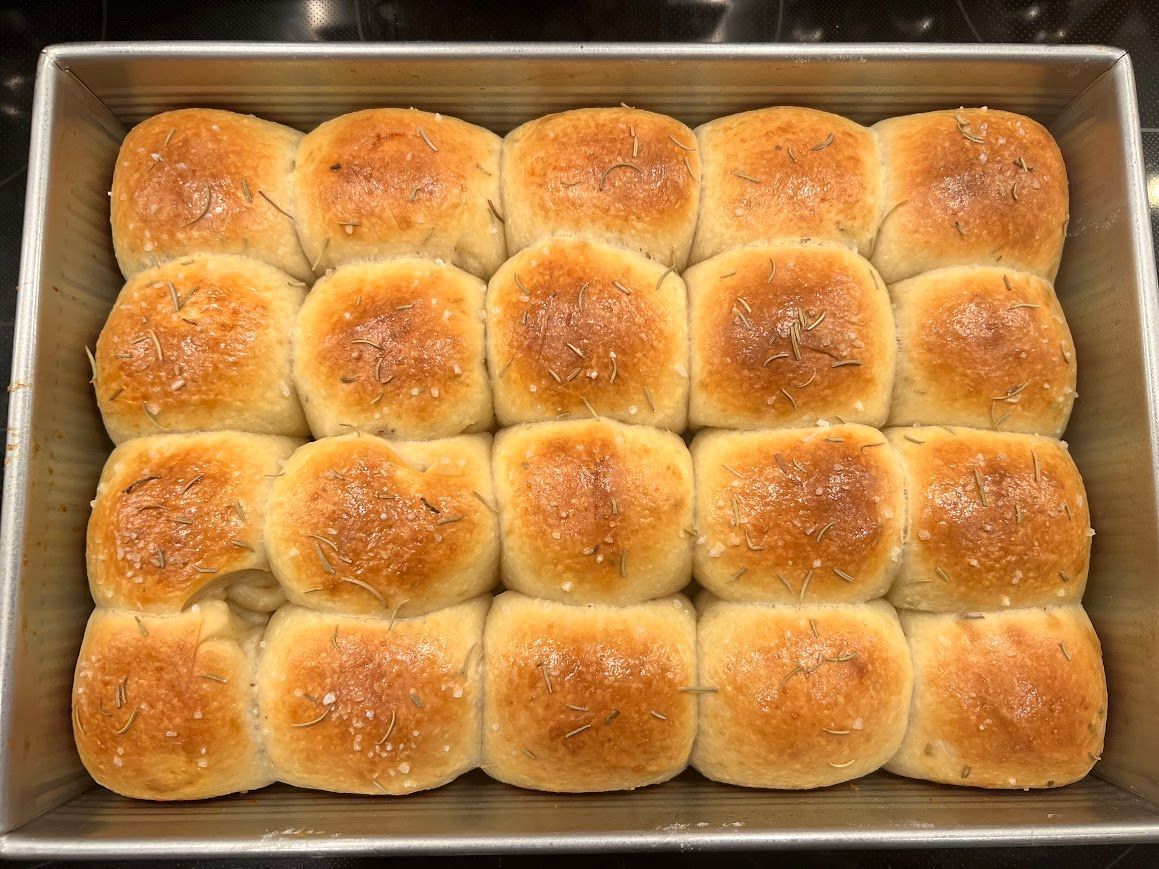 A pan filled with rolls is sitting on a counter.