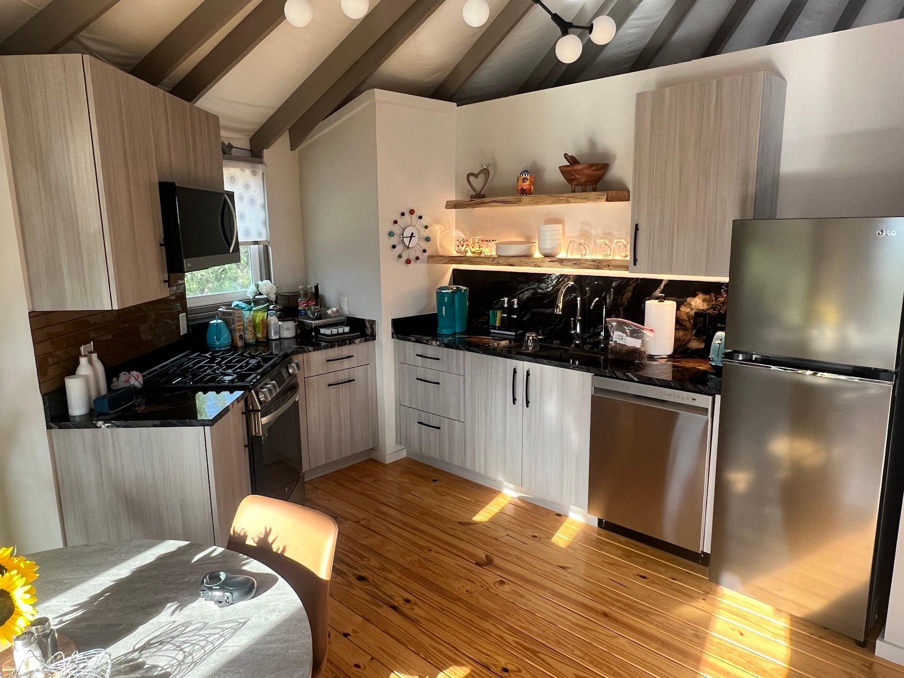 A kitchen with stainless steel appliances and wooden floors