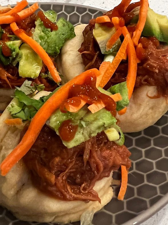 A close up of a plate of food with meat and vegetables on a table.