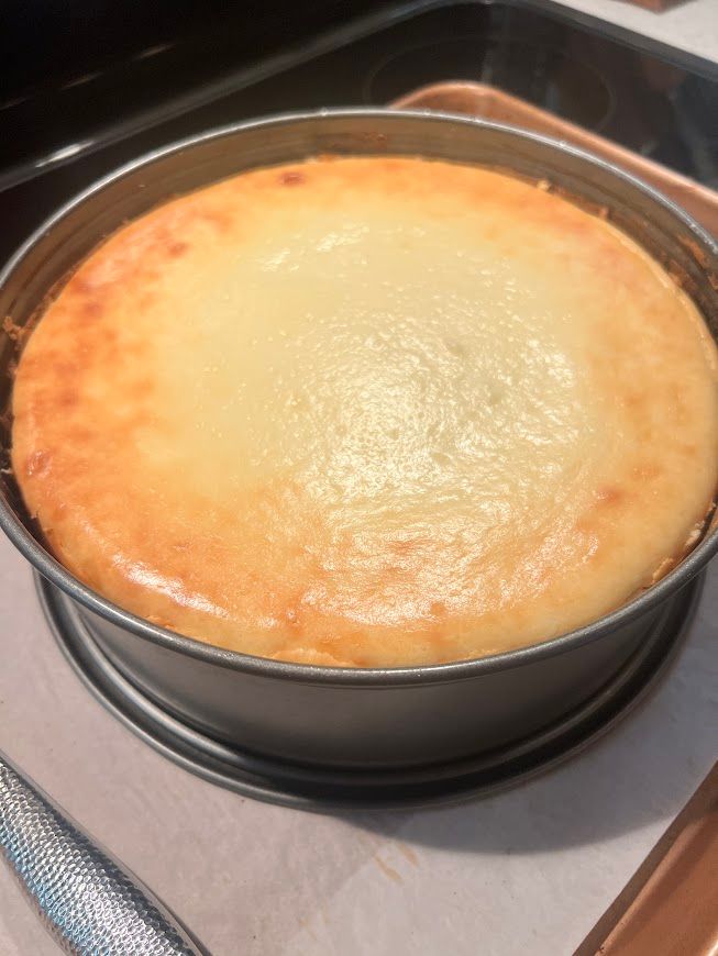 A cheesecake in a pan on a stove top