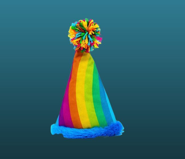 A rainbow party hat with a pom pom on top