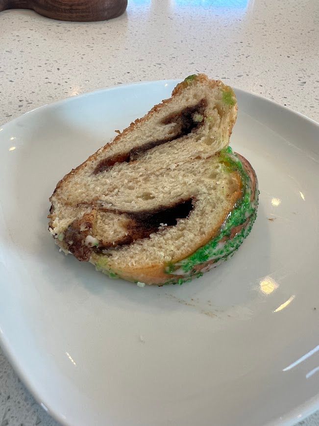 A slice of bread with green frosting is on a white plate.