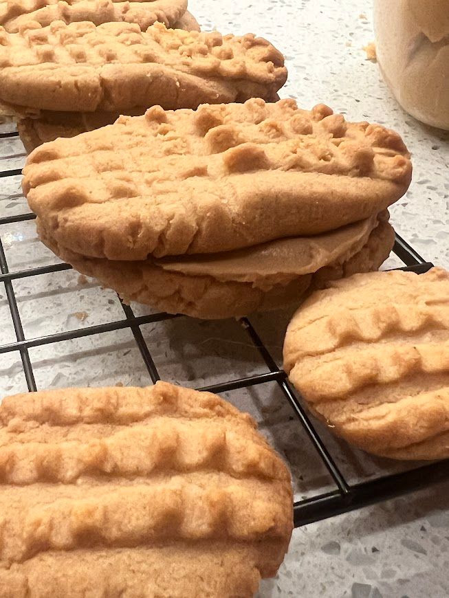 A row of peanut butter cookies sitting on top of a cooling rack.