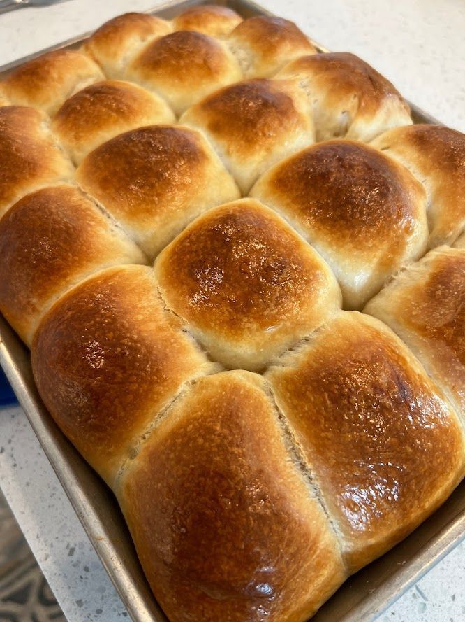 A pan filled with rolls is sitting on a counter.