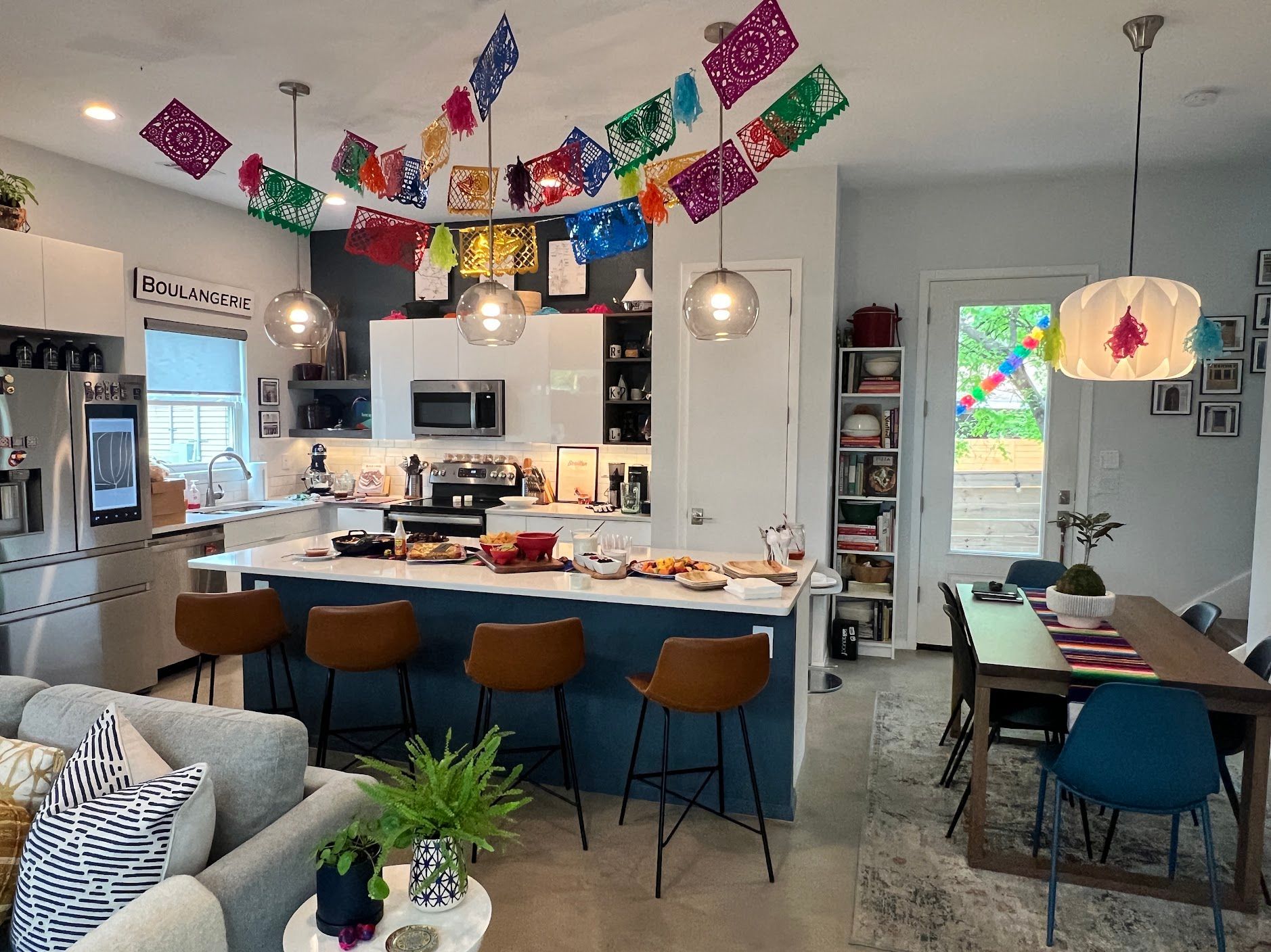 A kitchen with a table and chairs and a bunch of flags hanging from the ceiling.