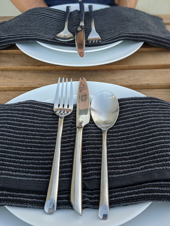 A person is sitting at a table with plates and silverware on it