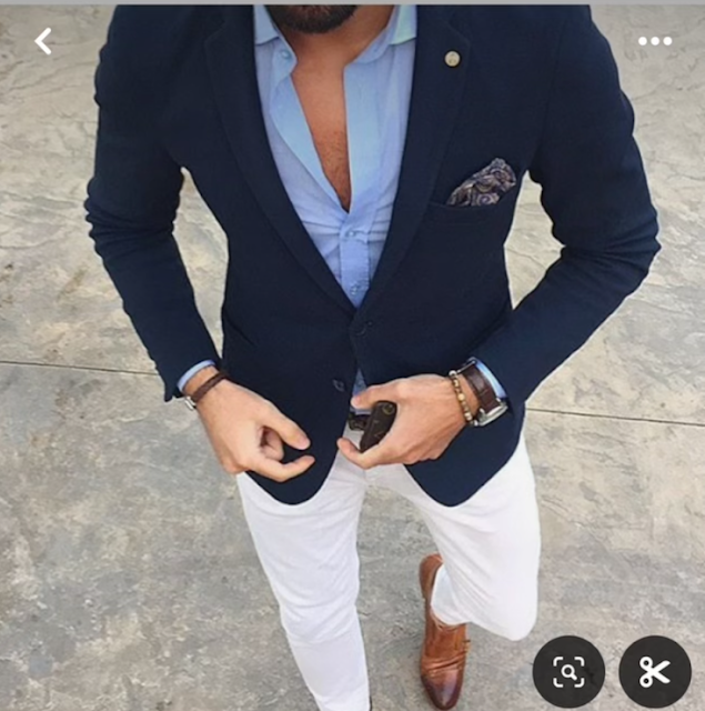 A man wearing a blue jacket and white pants