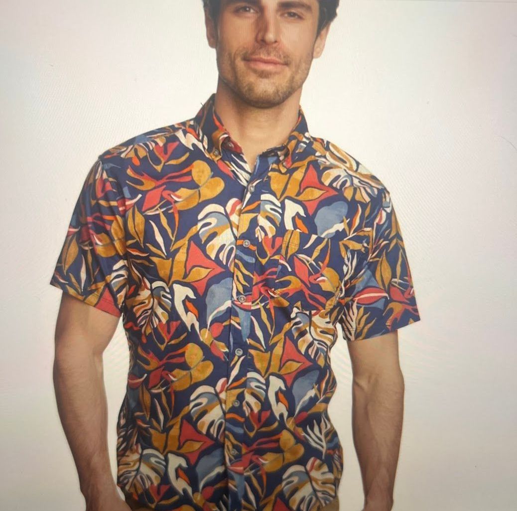A man wearing a colorful shirt with leaves on it