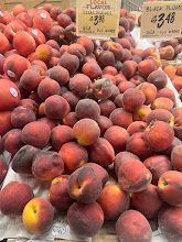 A bunch of peaches are sitting on top of each other on a table.