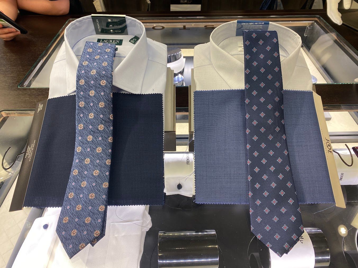 Two shirts and two ties are on display in a store