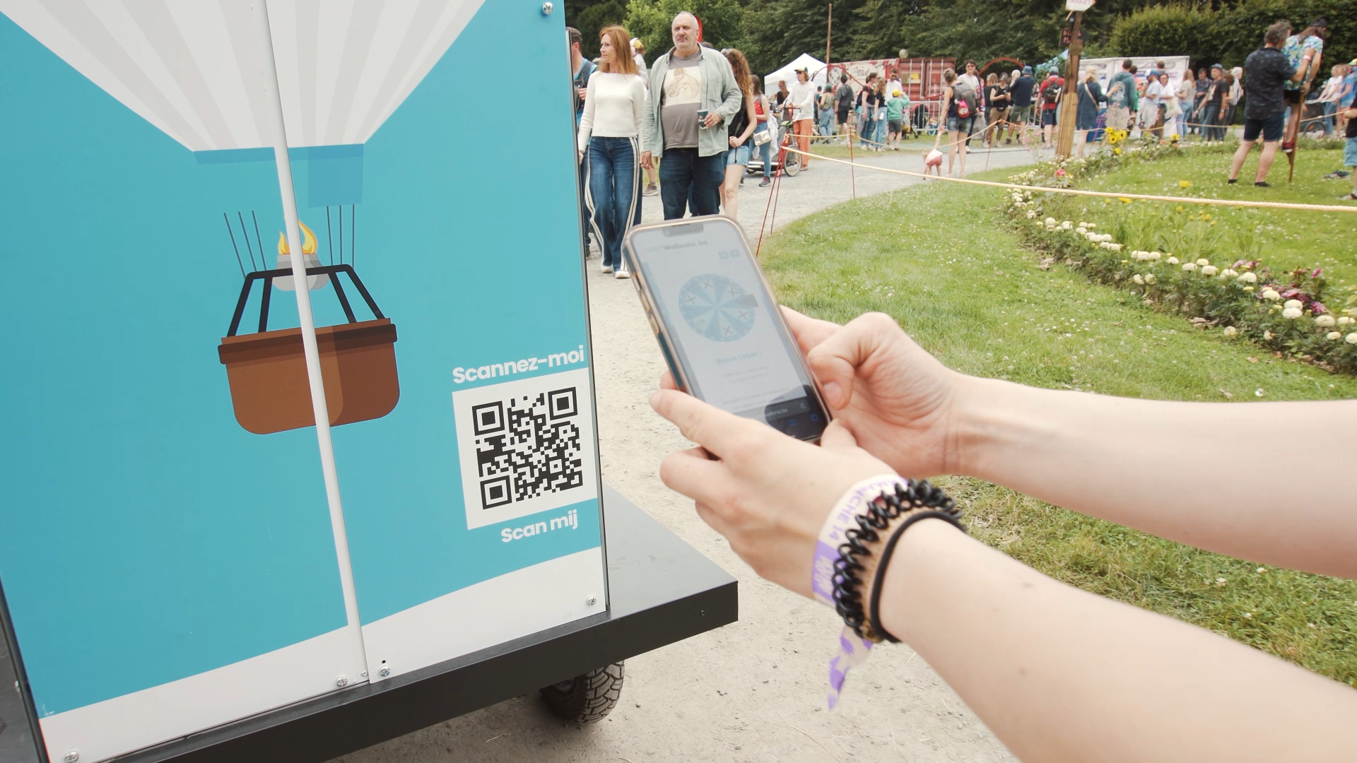 Personne qui scanne un des QR code présent sur le vélo EYE SCREEN aux couleurs de Visit Wallonia
